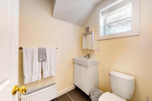 a bathroom with a toilet and a sink and a window at Pleasant Street Apartments in Ludlow