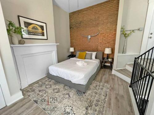 a bedroom with a bed and a brick wall at Quiet 1-Bedroom Loft near Entertainment District in Cincinnati