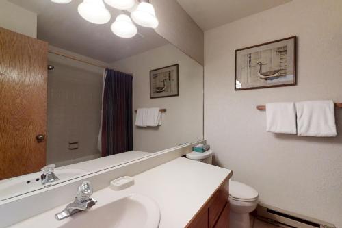 a bathroom with a sink and a toilet and a mirror at Snow Flower 309 in Steamboat Springs