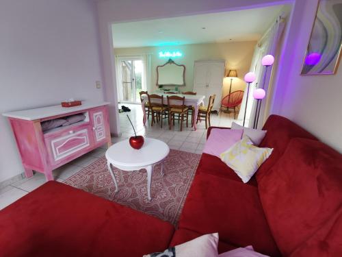 a living room with a red couch and a table at Izzy's Rainbow House in De Haan
