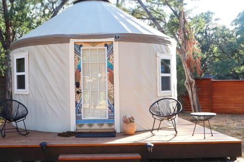 オースティンにあるCamposanto Glamping - The Peacock Yurtのパオとテーブル、椅子が備わるデッキ