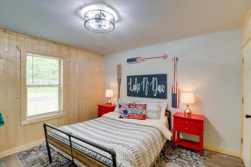 een slaapkamer met een bed en twee rode nachtkastjes bij Beautiful Studio Cabin Near Greers Ferry Lake! in Fairfield Bay