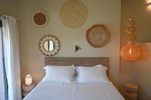 a bedroom with a bed with white pillows and mirrors at Villa ALFONSA in Saint-Raphaël
