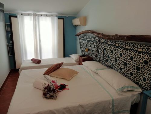Casa vacanze da CLARA في كاستروفيلاري: غرفة نوم بسريرين عليها ورد