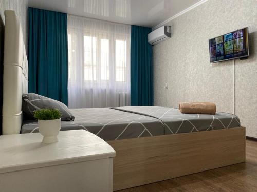 um quarto com uma cama e uma cortina verde em 1 ком квартира в районе City center em Oral