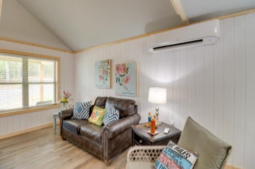 a living room with a leather couch and a table at Studio Cabin in Higden Boating, Fishing and More! in Fairfield Bay