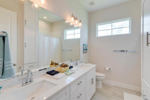 a white bathroom with a large mirror and a sink at Seas The Day Home with Pool Access in Galveston in Galveston
