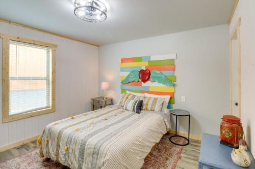 a bedroom with a bed and a painting on the wall at Cozy Studio Cabin about 1 Mi to Greers Ferry Lake! in Fairfield Bay