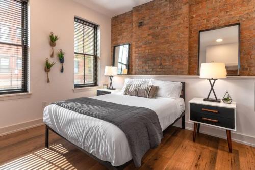 a bedroom with a bed and a brick wall at WALK TO ALL in Over The Rhine Cincinnati in Cincinnati