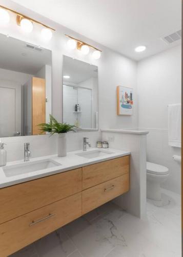 a bathroom with two sinks and a mirror and a toilet at WALK TO ALL in Over The Rhine Cincinnati in Cincinnati