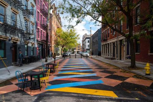 an empty street with tables and chairs on a sidewalk at WALK TO ALL in Over The Rhine Cincinnati in Cincinnati