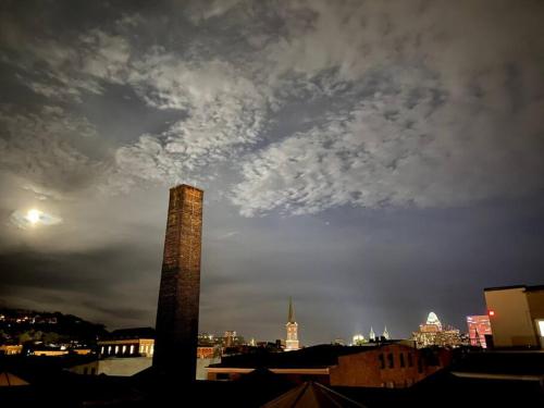 a tall tower in a city with a cloudy sky at WALK TO ALL in Over The Rhine Cincinnati in Cincinnati