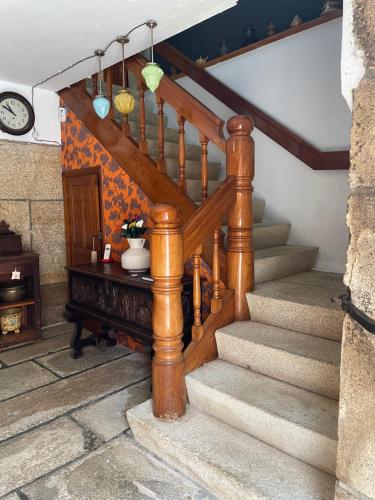 eine Holztreppe in einem Haus mit einem Tisch in der Unterkunft CASA DE PARDO in A Coruña