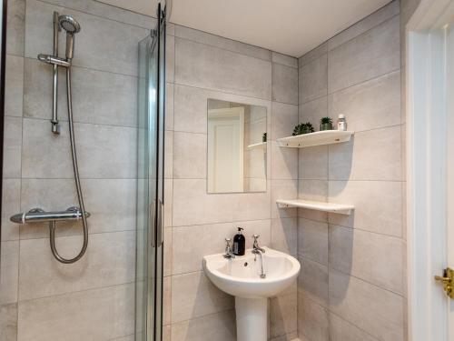 W łazience znajduje się prysznic, umywalka i toaleta. w obiekcie Mistletoe Cottage w mieście Bamburgh