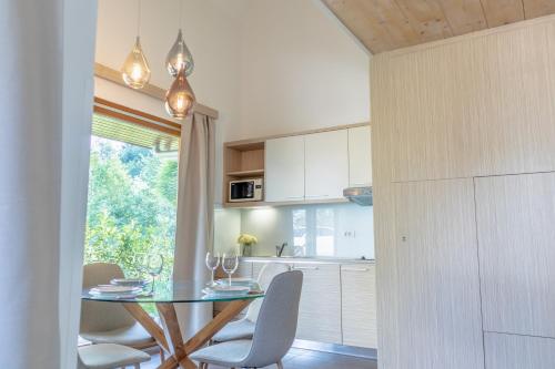 a kitchen with a glass table and chairs and a window at Apartment Rosemary in Topolšica