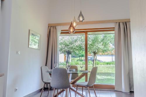 ein Esszimmer mit einem Tisch, Stühlen und einem Fenster in der Unterkunft Apartment Rosemary in Topolšica