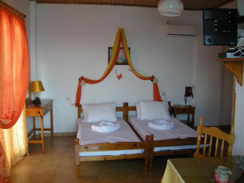a bedroom with a bed with a headboard and a table at Alkioni Studios in Karlovasi