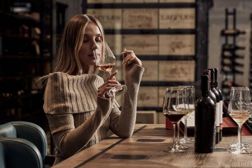 a woman sitting at a table with a glass of wine at Parklane, a Luxury Collection Resort & Spa, Limassol in Limassol