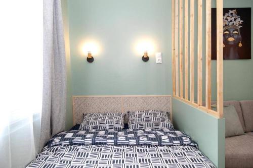 een kleine slaapkamer met een bed met gestreepte kussens bij Studio cozy, proche paris in Pré Saint Gervais