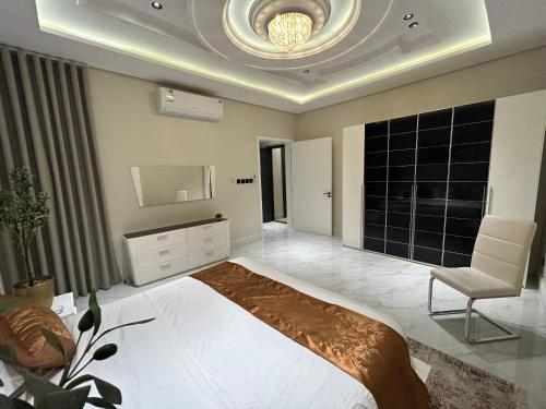 a bedroom with a bed and a tv and a chair at شقة فاخرة غرفة وصالة بالعارض دخول ذاتي ٦ in Riyadh