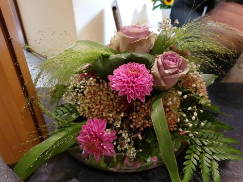 a bouquet of pink flowers in a glass vase at Hotel & Restaurant Zum Deutschen Hause in Kirchhatten