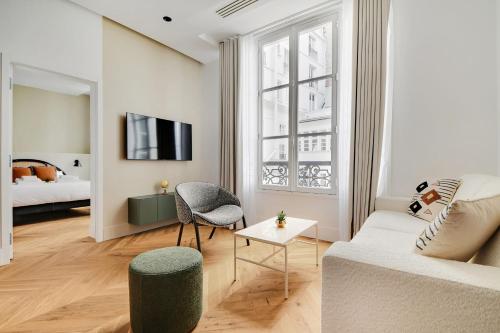 un salon avec un canapé et un lit dans l'établissement Moderne appartement - 1BR 4P - Opéra, à Paris