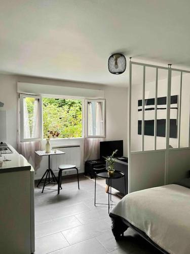 1 dormitorio con cama, mesa y ventana en Studio 30 m2 a 900 m du rer E, en Champigny-sur-Marne