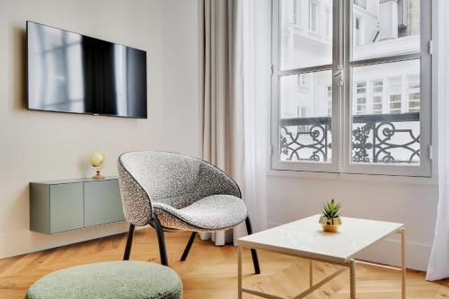 un salon avec une chaise et une table dans l'établissement Moderne appartement - 1BR 4P - Opéra, à Paris