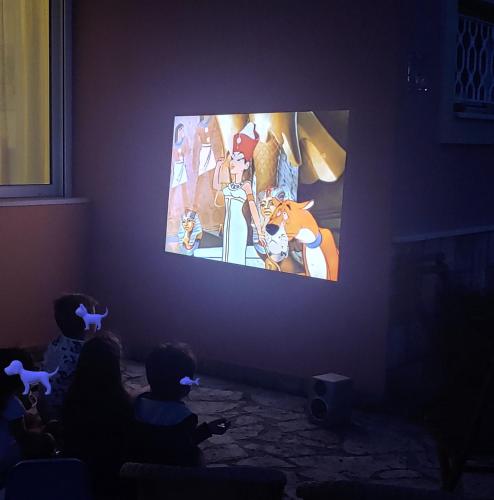 two children playing a video game in a dark room at Captain Alex Villa 1 in Dafnila
