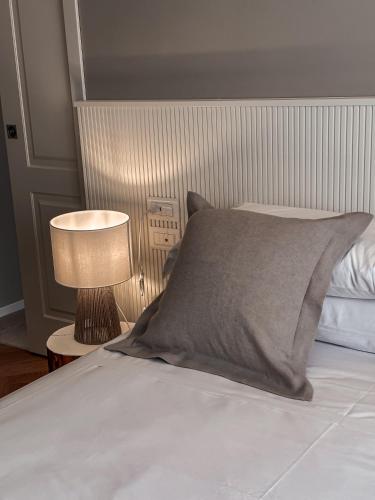 a bed with a gray pillow and a lamp at B&B Palazzo Bruni - Dimora di Mare in Marina San Vito