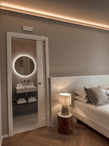a bedroom with a bed and a mirror and a lamp at B&B Palazzo Bruni - Dimora di Mare in Marina San Vito