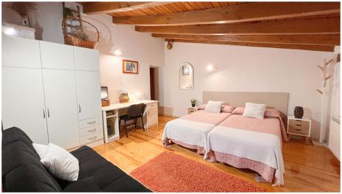 Miranda de ArgaにあるCasa Rural Xixa Landetxeaのベッドルーム1室(ベッド2台、デスク、ソファ付)