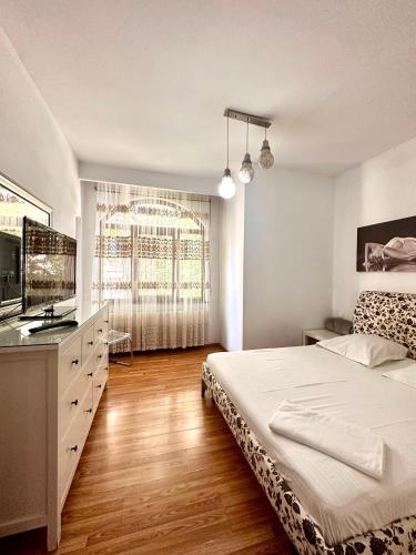 a bedroom with a bed and a large window at Budapest Residence in Bucharest