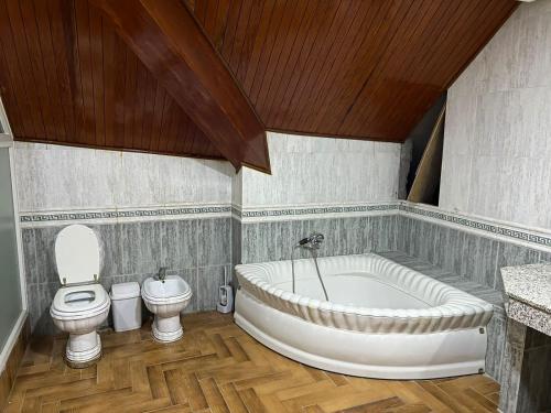 a bathroom with a large tub and a toilet at Centre ville hay Riad 06 69 soixante-huit trente-huit vingt-huit in Ifrane