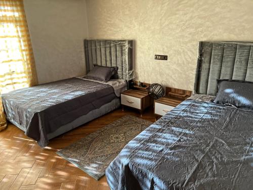 1 dormitorio con 2 camas y suelo de madera en Centre ville hay Riad 06 69 soixante-huit trente-huit vingt-huit en Ifrane