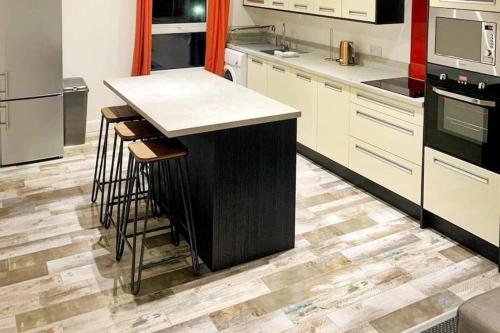 a kitchen with a island in the middle of a kitchen at Tower Suite Serviced Apartment Blackpool in Blackpool