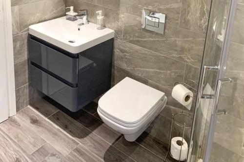 a bathroom with a toilet and a sink and a shower at Tower Suite Serviced Apartment Blackpool in Blackpool