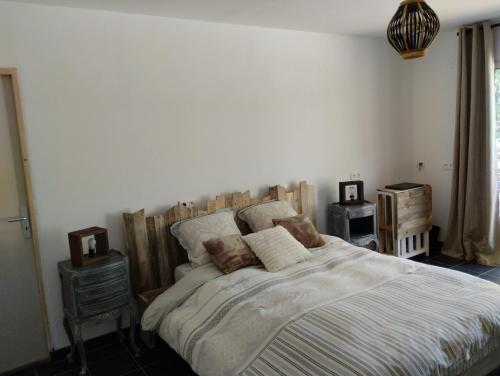 a bedroom with a large bed with a wooden headboard at La guitoune in Laroque