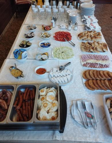 a table full of food on a white table cloth at ĆAKA Luxury Rooms & Restaurant in Ćuprija