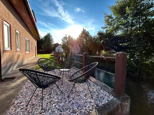 two chairs sitting on a patio next to a body of water at Creekside House K in Mozirje