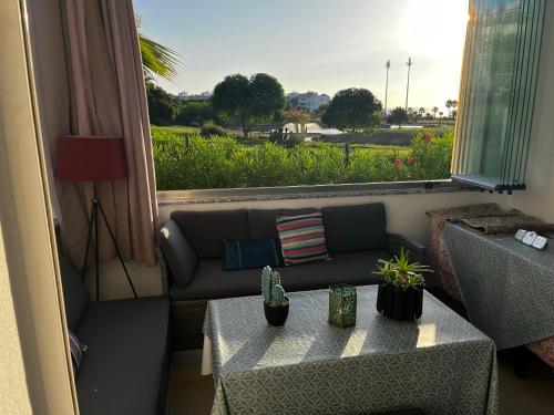 アシラにあるMarina golf ASSILAH vue verteのソファとテーブルと窓のあるリビングルーム