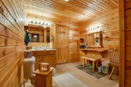 a log cabin bathroom with a sink and a toilet at Home Sweet Log in Wisconsin Dells