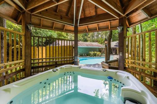 a large outdoor hot tub in a pavilion with a pool at Bourbon Hollow Lodge with Hot Tub and Pool plus Game Room only 5 min to downtown in Gatlinburg