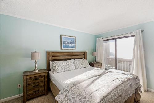 a bedroom with a large bed and a window at Dunescape Villas 221 in Atlantic Beach
