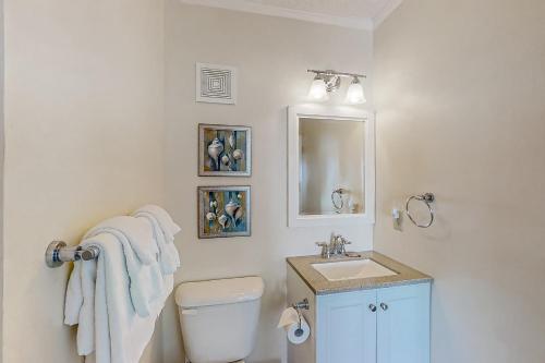 a bathroom with a white toilet and a sink at Dunescape Villas 221 in Atlantic Beach