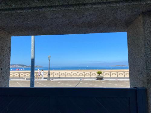 a view of the beach from a window at PRIMERA LINEA PLAYA AMERICA in Nigrán
