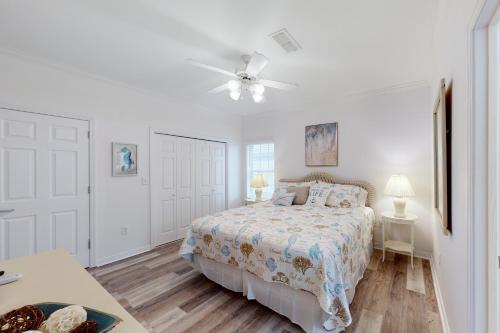 a white bedroom with a bed and a ceiling fan at Dauphin Island Beach Club 210A in Dauphin Island