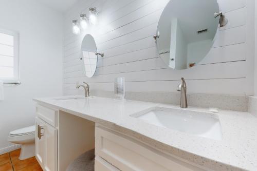 a white bathroom with a sink and a mirror at Dauphin Island Beach Club 210A in Dauphin Island
