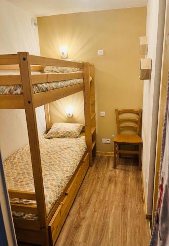 a bedroom with two bunk beds and a chair at T2 cabine 6 pers au pied des pistes in Orcières