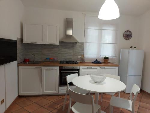 una cucina con tavolo bianco e frigorifero bianco di Casa Gio' IUN R4246 a Solanas